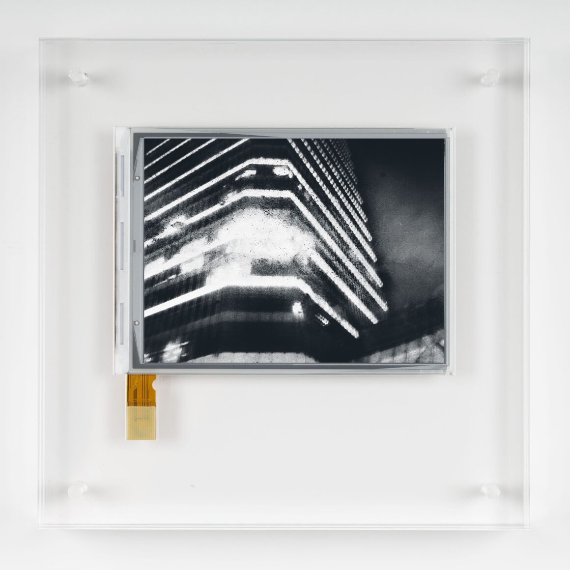 Antony Cairns’in Fotoğrafları Ka’da 4 E.I. PVD27 2023 E ink screen encapsulated in Perspex box. Negative Date 2019 10.1cm x 12.9cm 20 x 20 x 3.2cm with frame Unique min